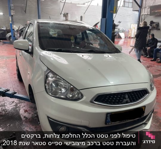 רכב לבן במוסך עם כלי עבודה על הרצפה